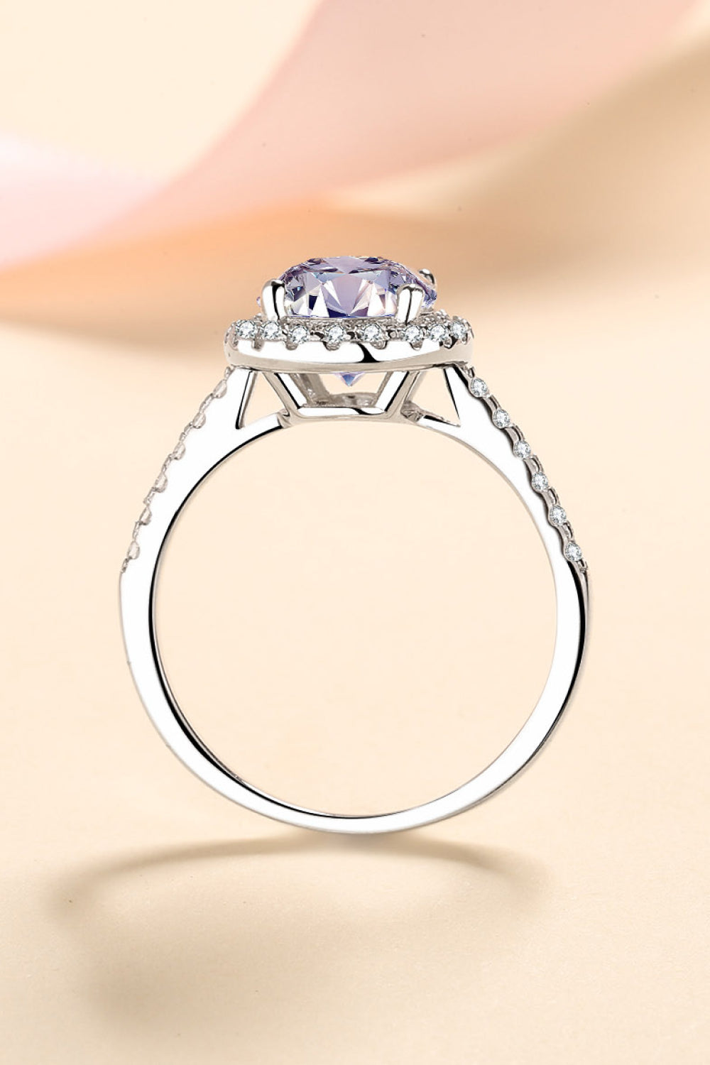 Silver pavé halo solitaire ring with a large purple center stone and diamond accents on the band.