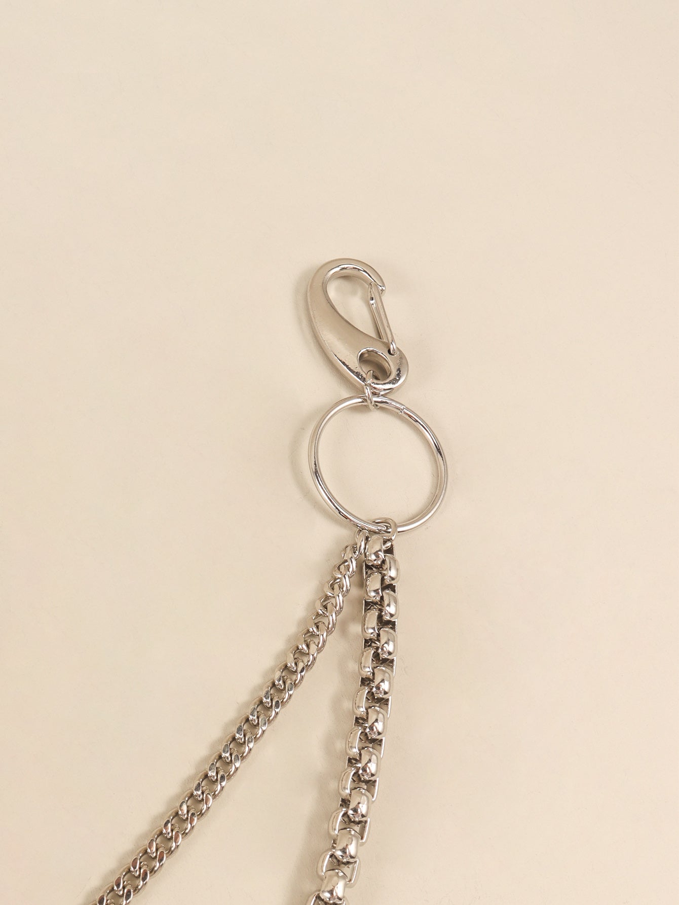 Silver double-strand chain pant accessory with carabiner clip and ring detail.
