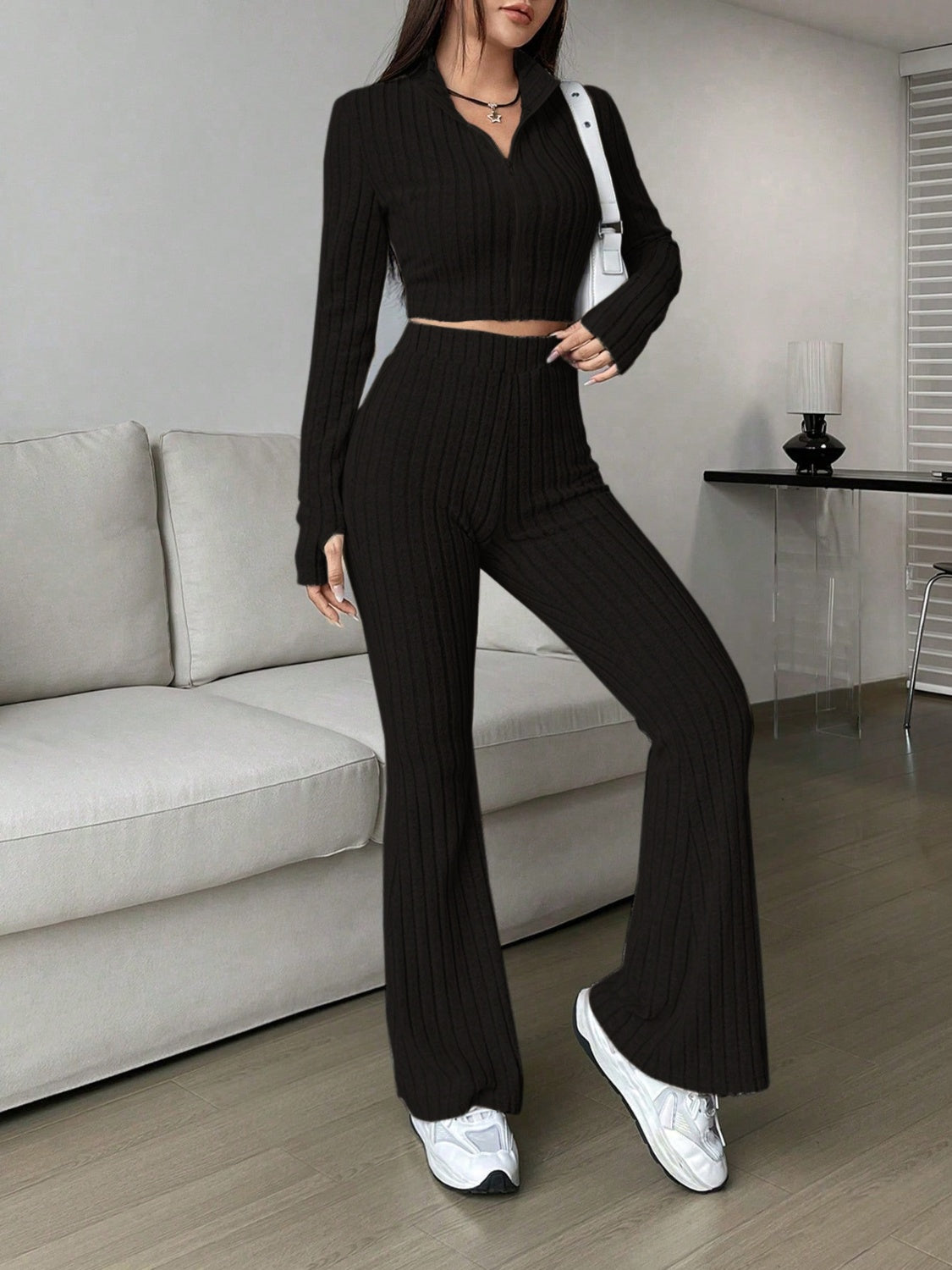 Black ribbed knit flare co-ord set with zip neck crop top and high waist pants.