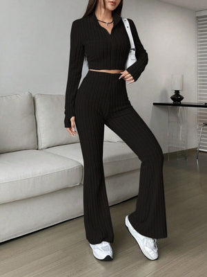 Black ribbed knit flare co-ord set with zip neck crop top and high waist pants.