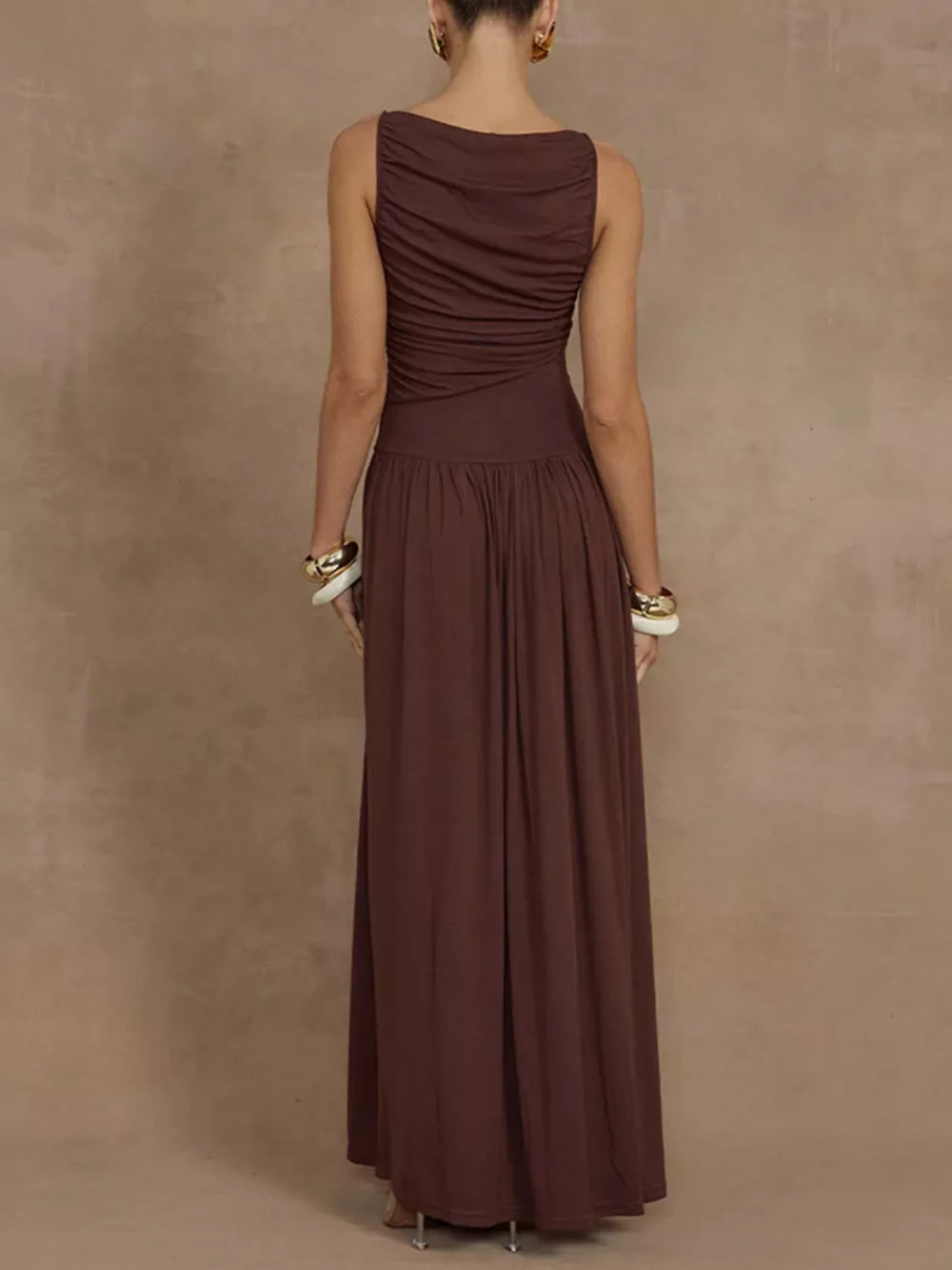 Brown ruched sleeveless maxi dress with a gathered bodice and flowing skirt.