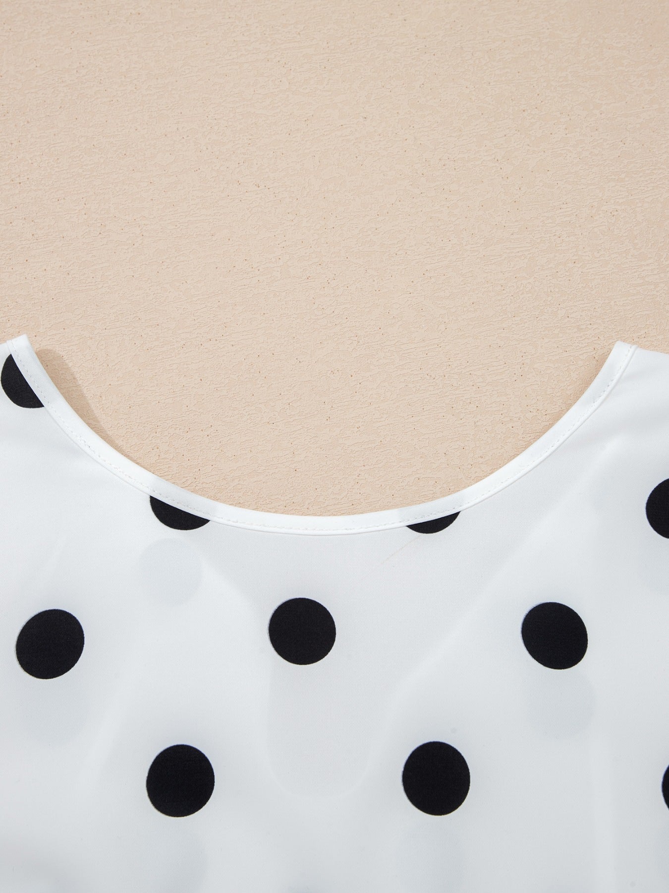 White polka dot blouse with a scoop neckline.
