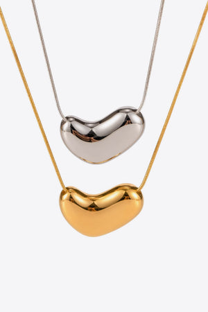 Gold and silver bean-shaped sculptural pendant necklaces on snake chains