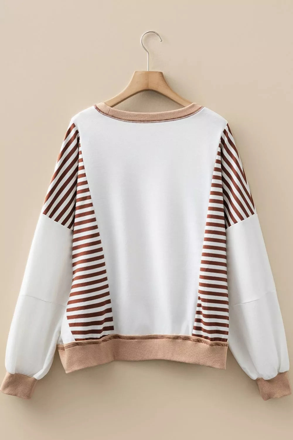 Chic colorblock sweatshirt with brown stripe sleeves and contrast stitching.