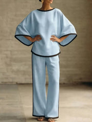 Blue two-piece set with boat neck top and wide leg pants, featuring contrast black trim.