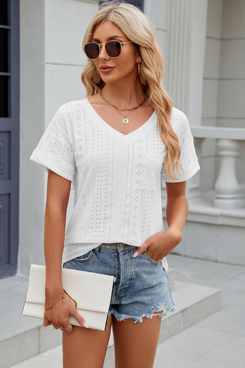 White perforated v-neck t-shirt with rolled sleeves and a chest pocket.