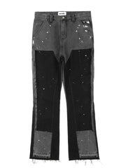 Split panel bootcut jeans in dark gray with black panels and white paint splatters.