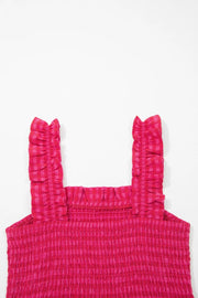 Pink gingham sundress with smocked bodice and ruffled straps.