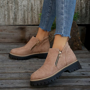 Brown suede ankle boots with side zippers and rugged soles.