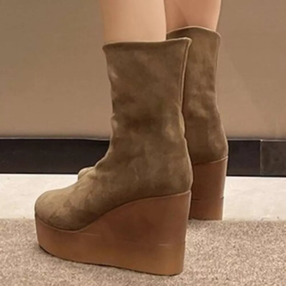Brown suede wedge boots with a platform sole and a smooth leather wedge.