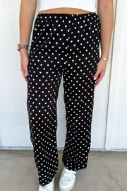 Chic polka dot wide-leg maternity trousers in black with white dots, featuring a comfortable elastic waistband.