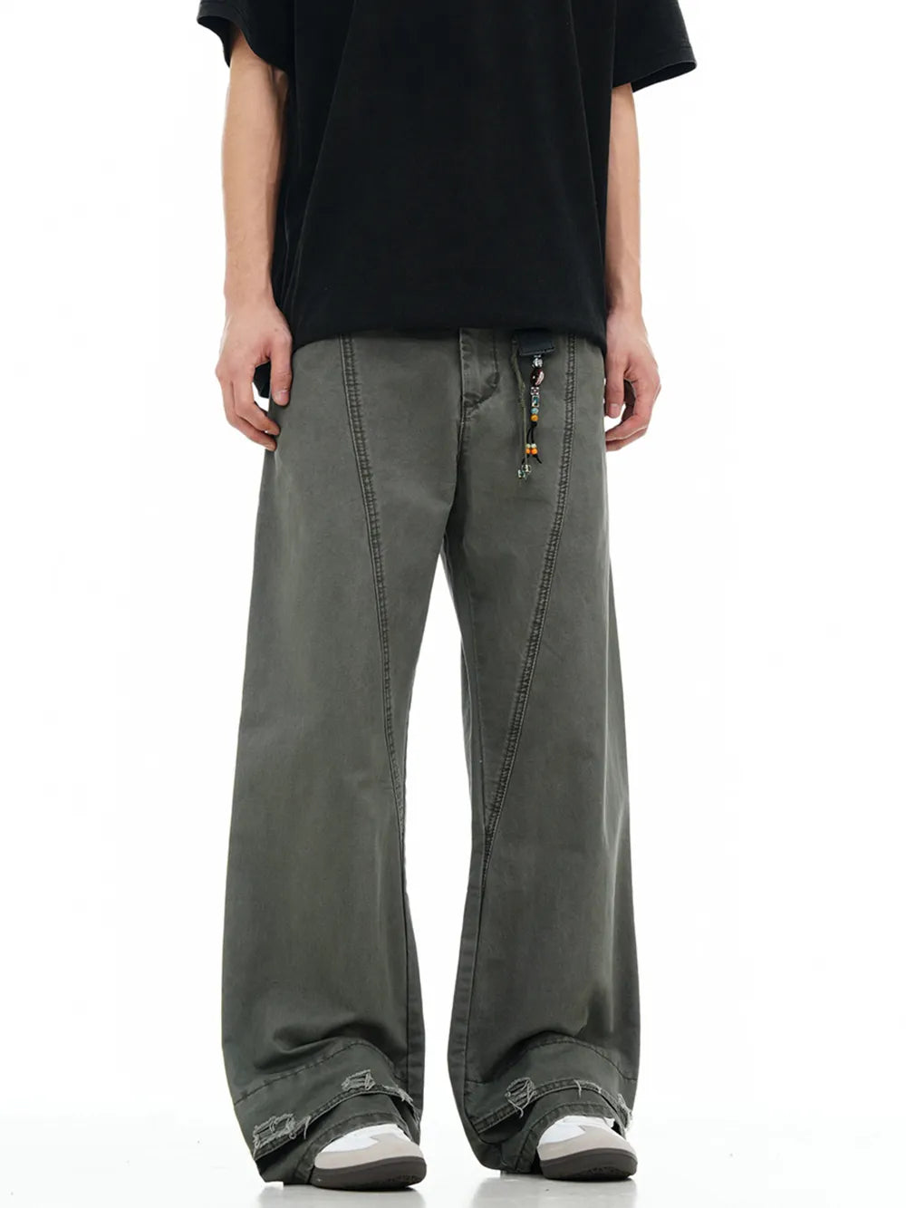 Men's grey wide-leg denim trousers with decorative beaded drawstring and distressed cuffs.
