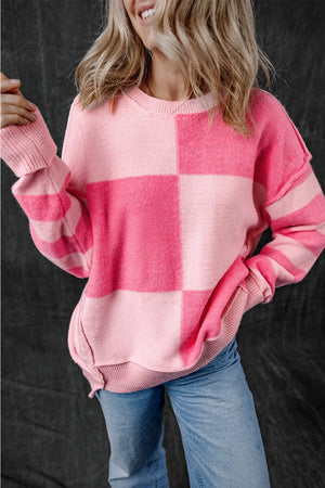 Checkerboard knit crewneck sweater in blush pink with striped sleeves.