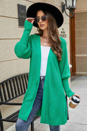 Green knit cardigan with puffed sleeves and a longline cut.