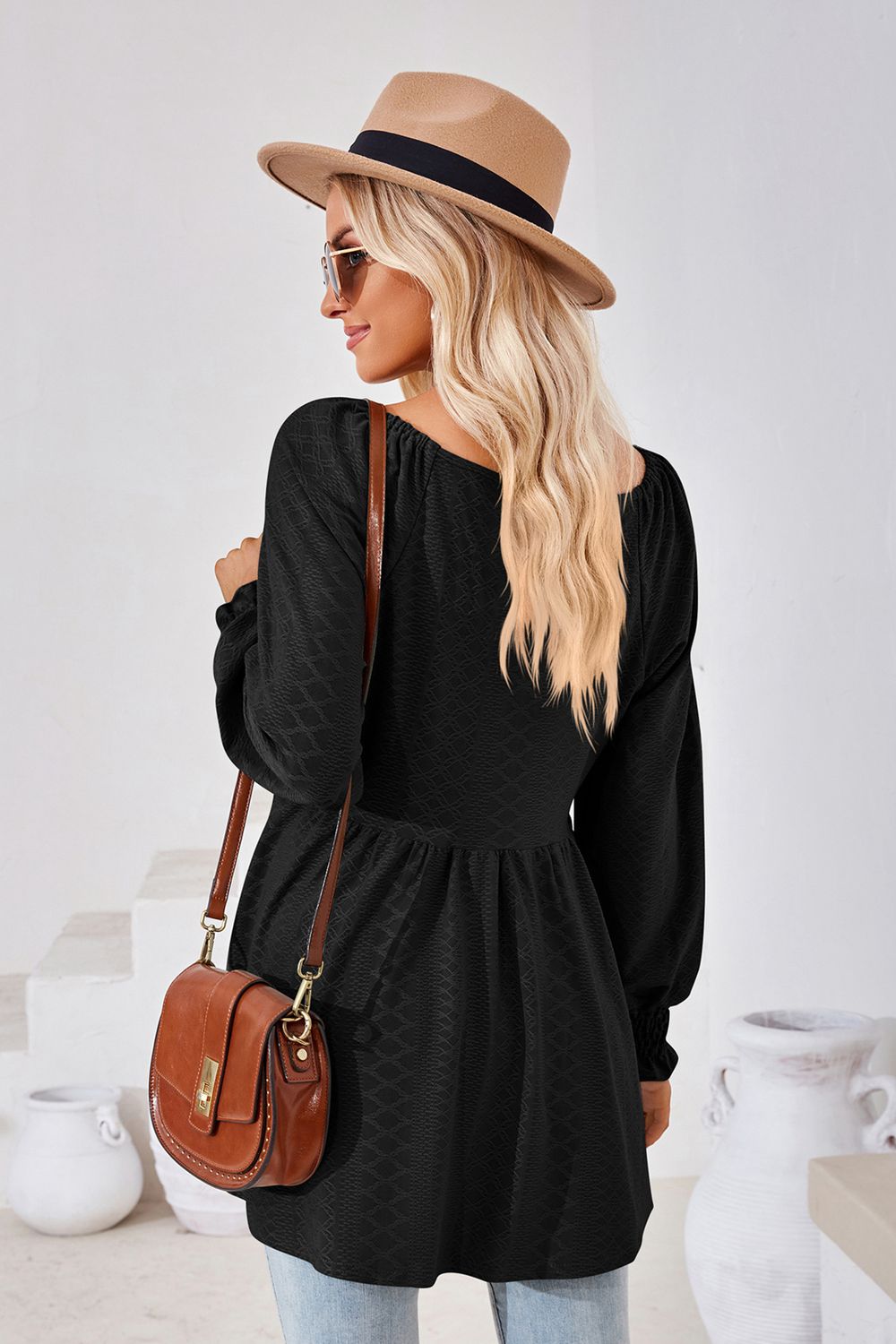 Black textured babydoll blouse with smocked cuffs and square neckline