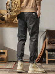 Men's dark gray slim fit ankle pants with a back pocket detail.
