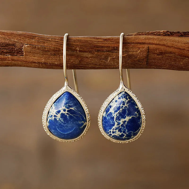 Marbled gemstone teardrop earrings in pastel blue with bezel setting and 18K gold-plated hooks.