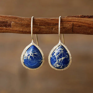 Marbled gemstone teardrop earrings in pastel blue with bezel setting and 18K gold-plated hooks.