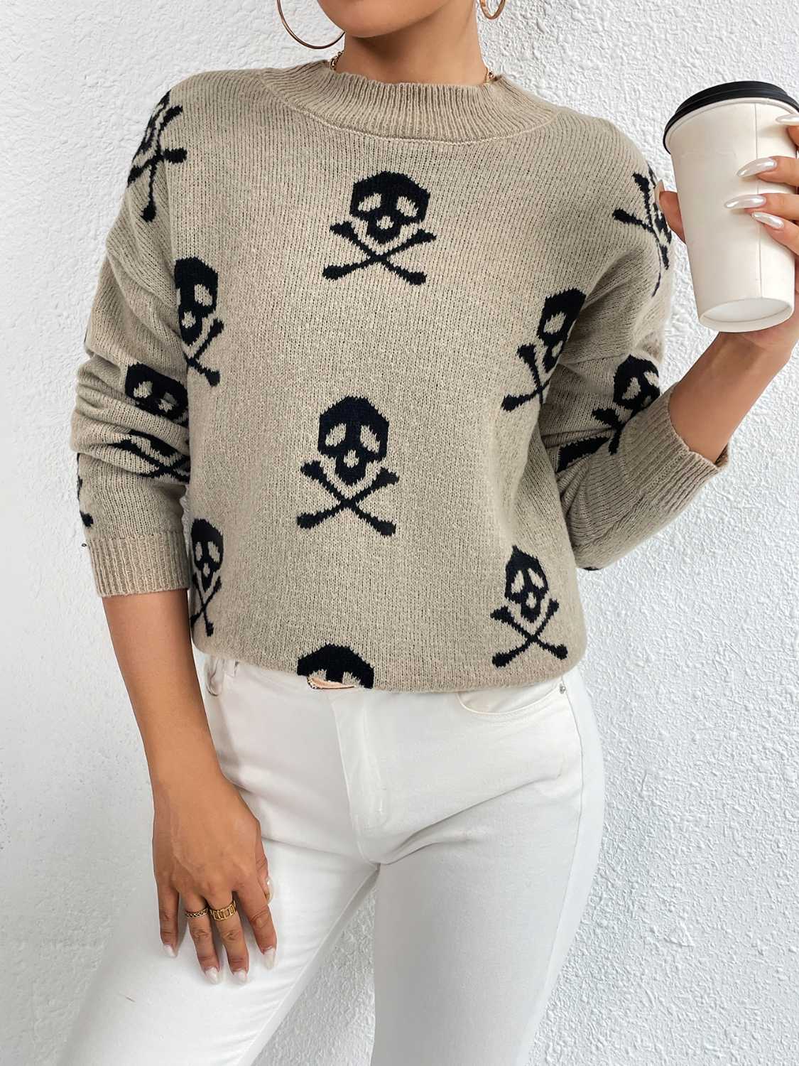 Khaki knit sweater with allover black skull and crossbones print, drop shoulder, and crew neck.
