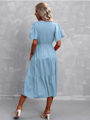 Light blue tiered midi dress with flutter sleeves and belted waist.