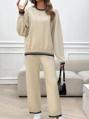 Beige knit lounge set with black ribbed trim on neckline, hem, and cuffs.