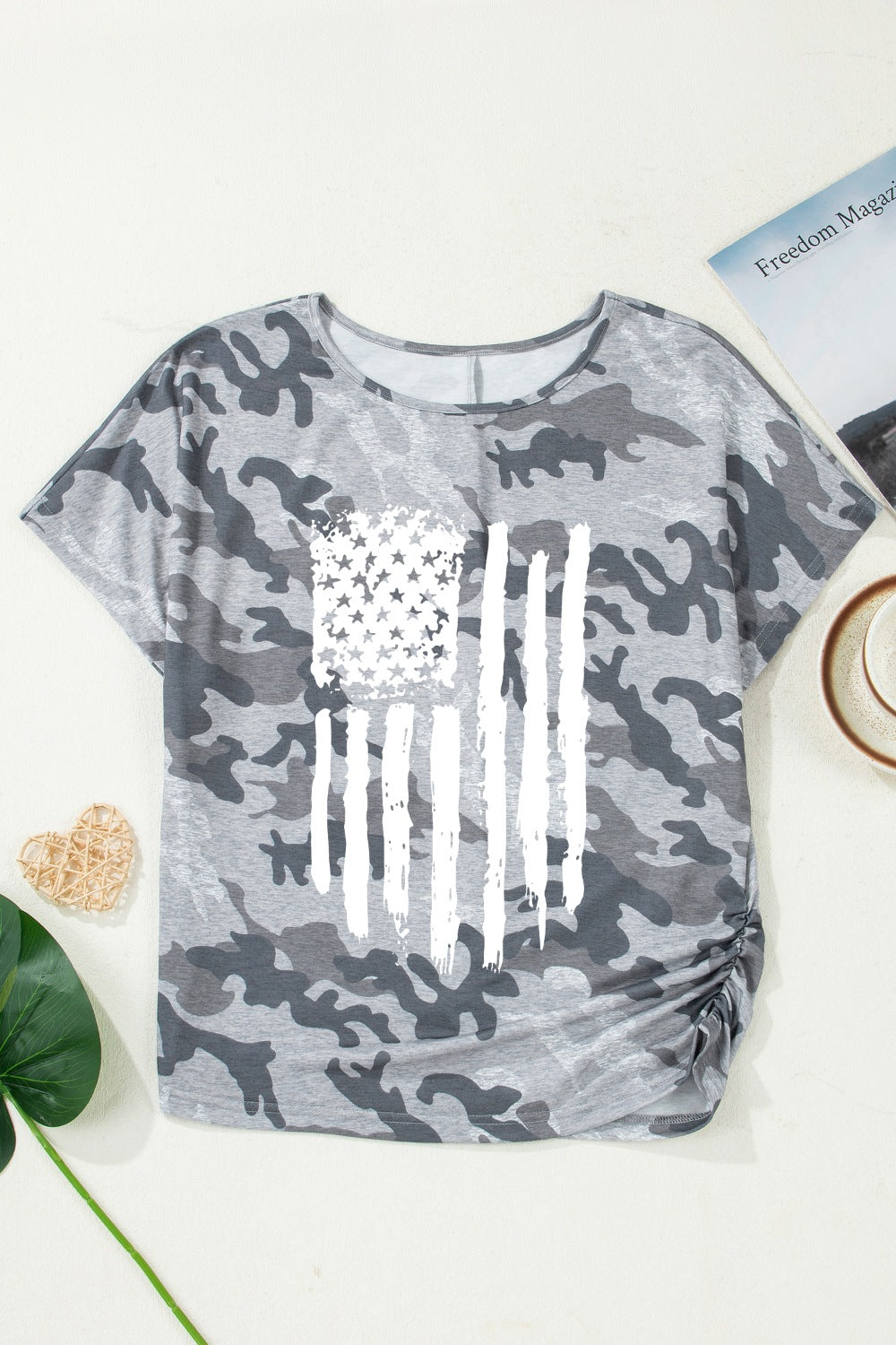 Grey camouflage crew neck t-shirt with distressed American flag graphic and ruched side detail.