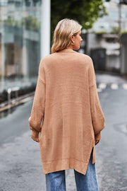 Open-knit longline cardigan in tan with side slits and textured sleeves.