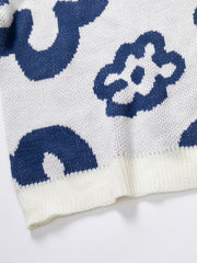 White acrylic knit crewneck sweater with a blue abstract floral pattern and ribbed trim.