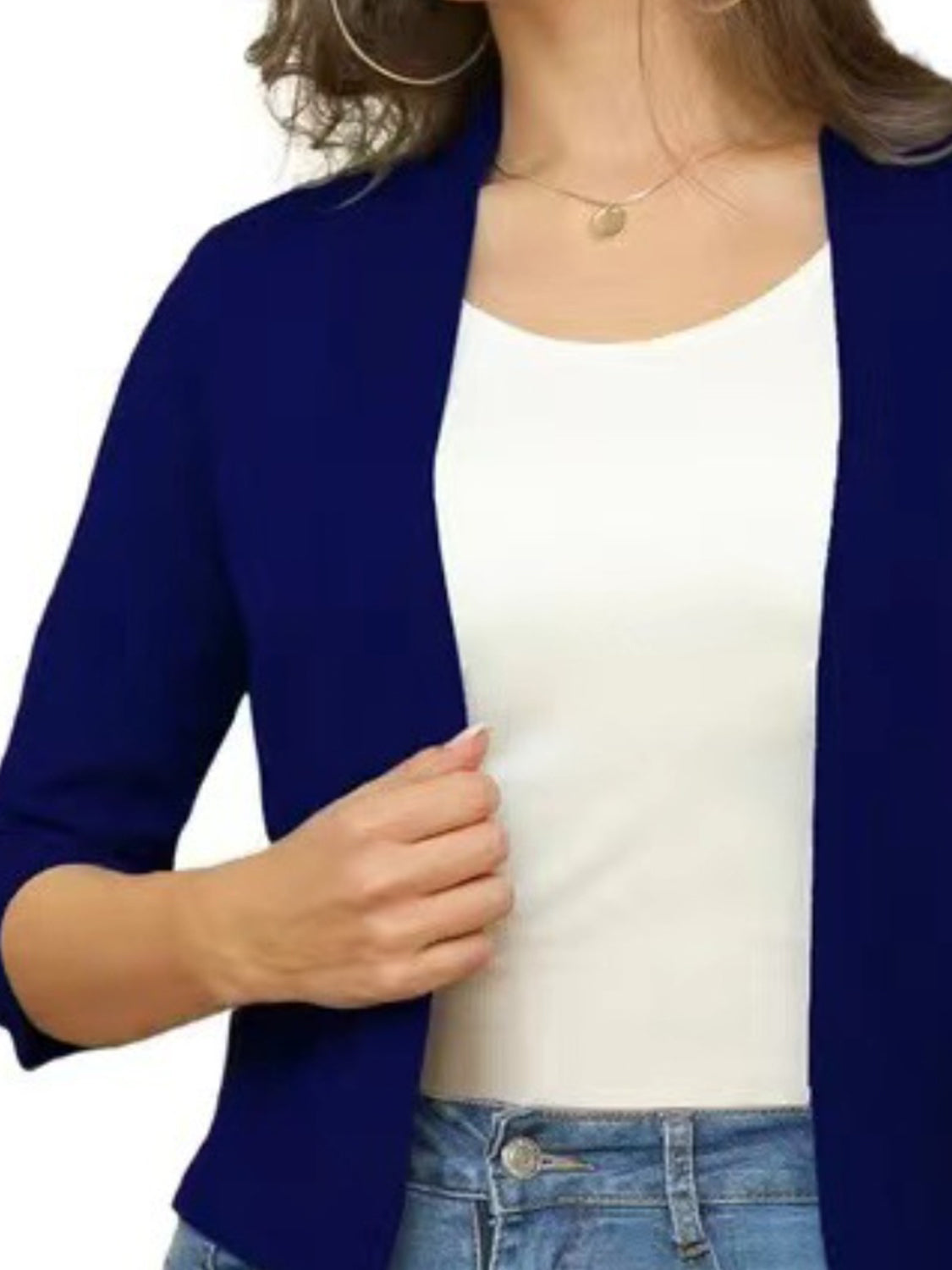Navy open-front cropped cardigan with elbow sleeves worn over a white top.