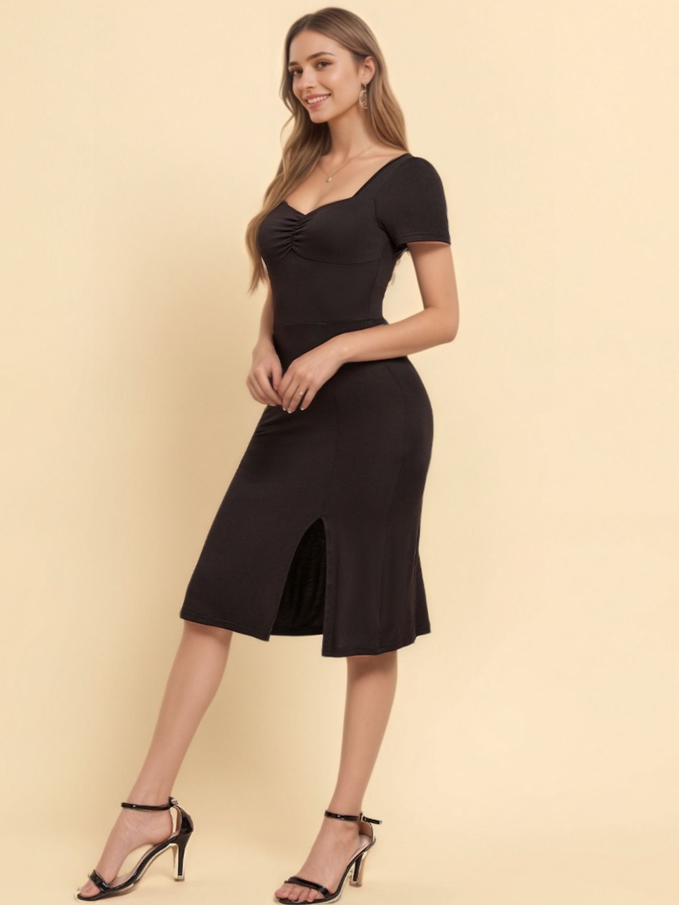 Black ruched sweetheart neck midi dress with short sleeves and a side slit.