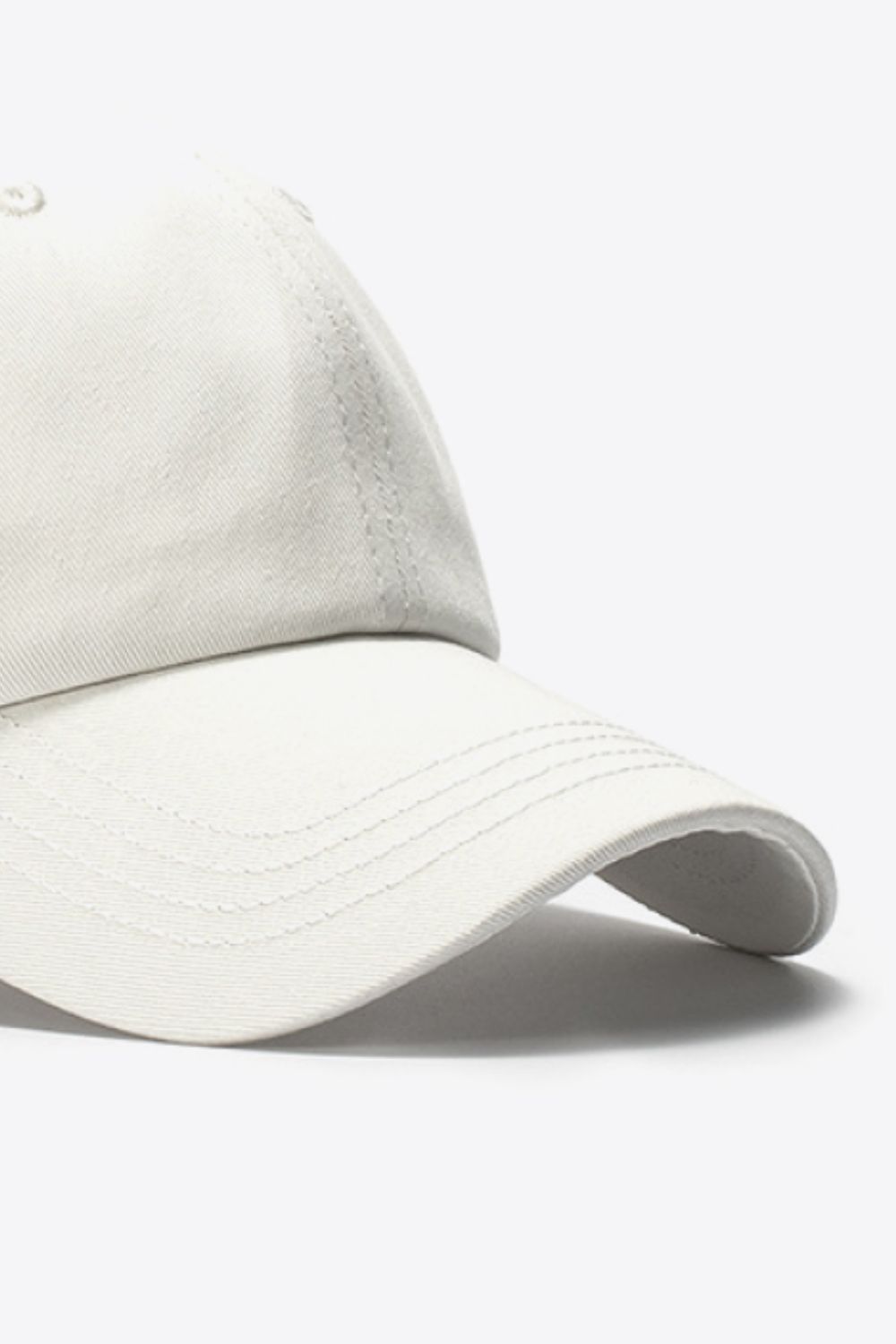Beige cotton baseball cap with stitched detailing on the brim.