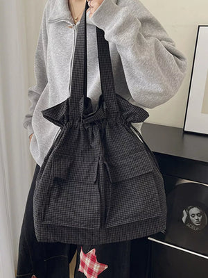 Chic plaid drawstring backpack in grey with multiple front pockets for everyday use.