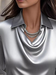 Gray satin cowl neck blouse with a collared neckline and layered necklace.