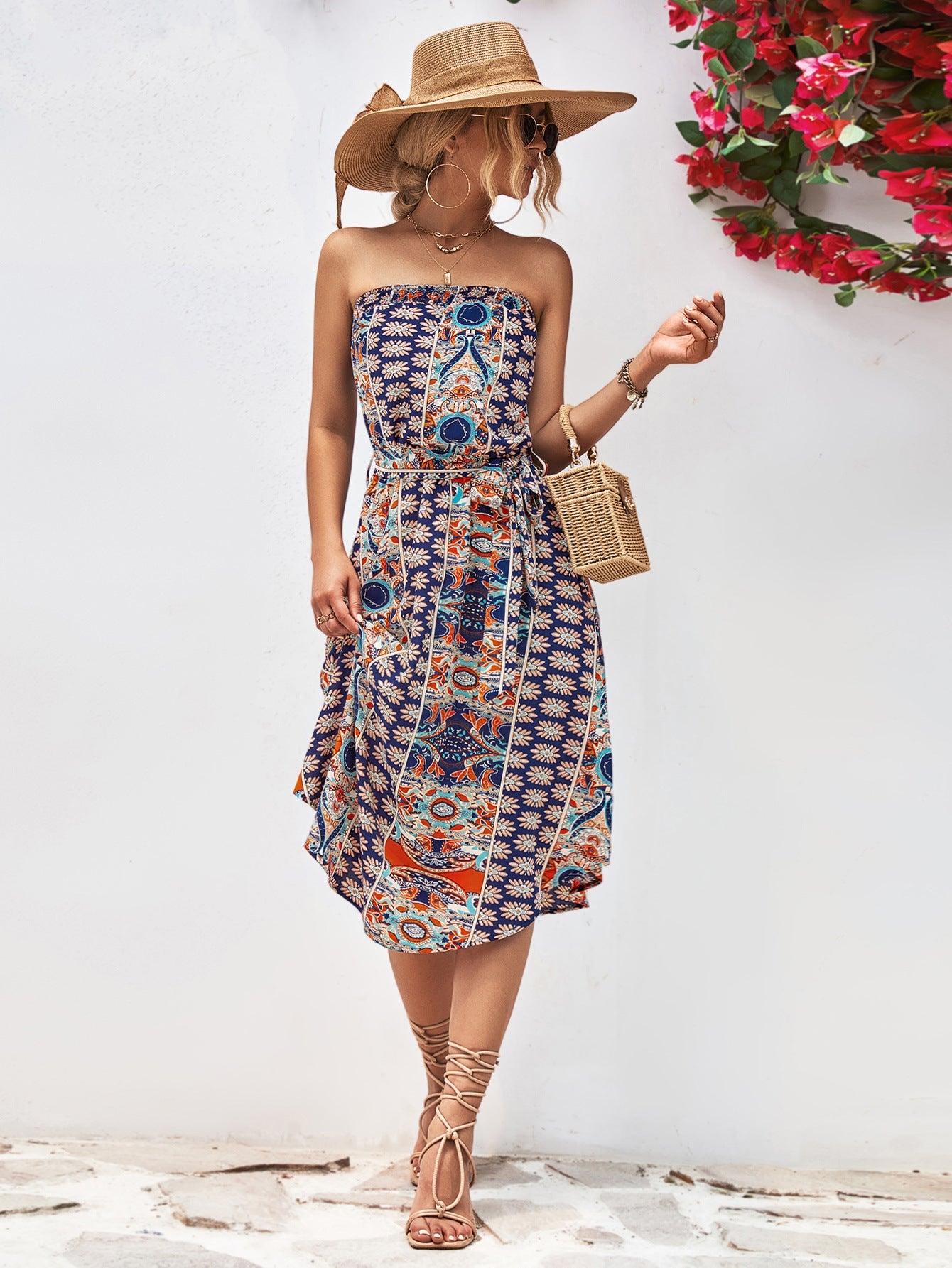 Printed bandeau midi dress with asymmetric hem and belt in dark blue and orange pattern.
