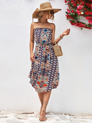 Printed bandeau midi dress with asymmetric hem and belt in dark blue and orange pattern.