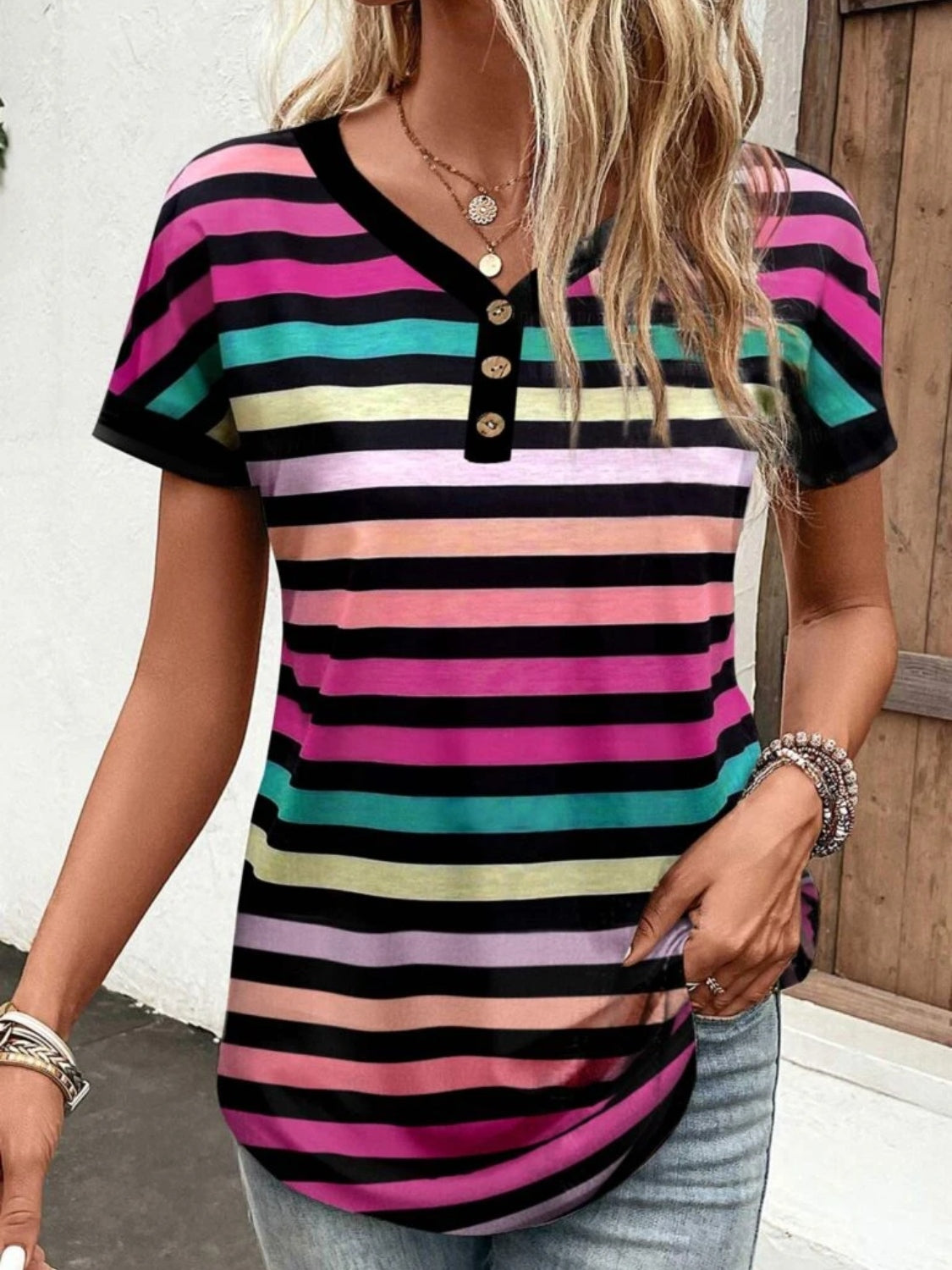 Rainbow stripe henley tee with button placket and black trim neckline.