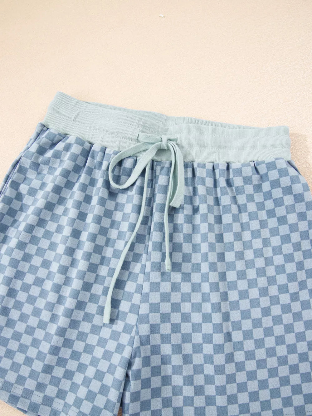 Light blue checkerboard shorts with a light blue drawstring waist and elastic band.