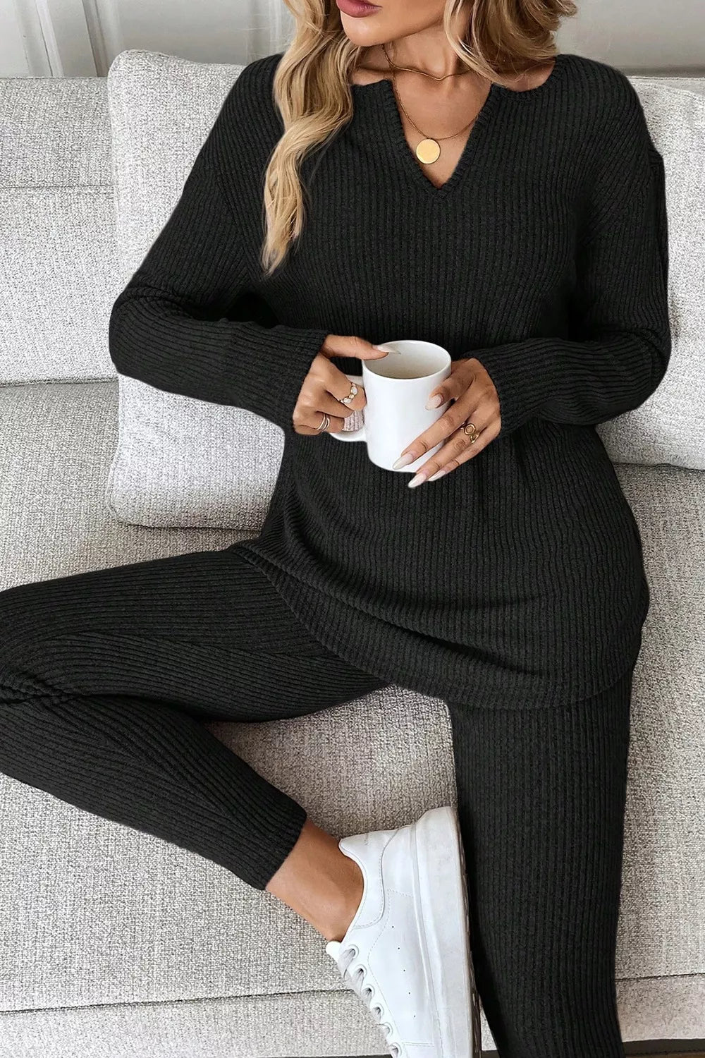 Black ribbed loungewear set with notched V-neck long sleeve top and matching pants.