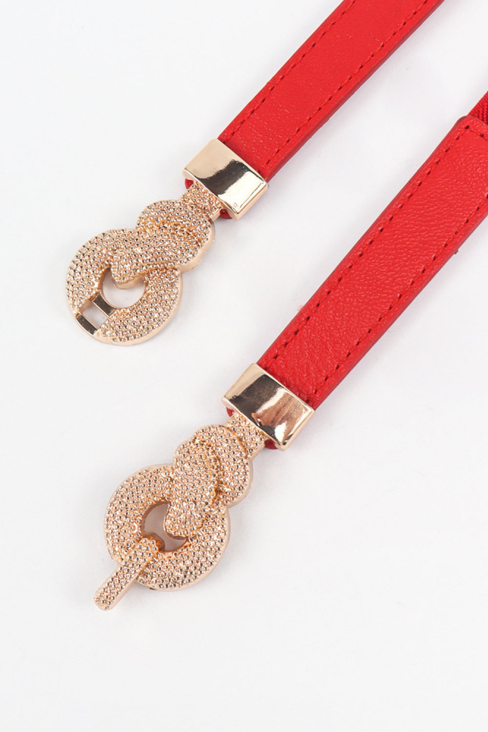 Red elasticated waist belt with gold alloy knot detail.