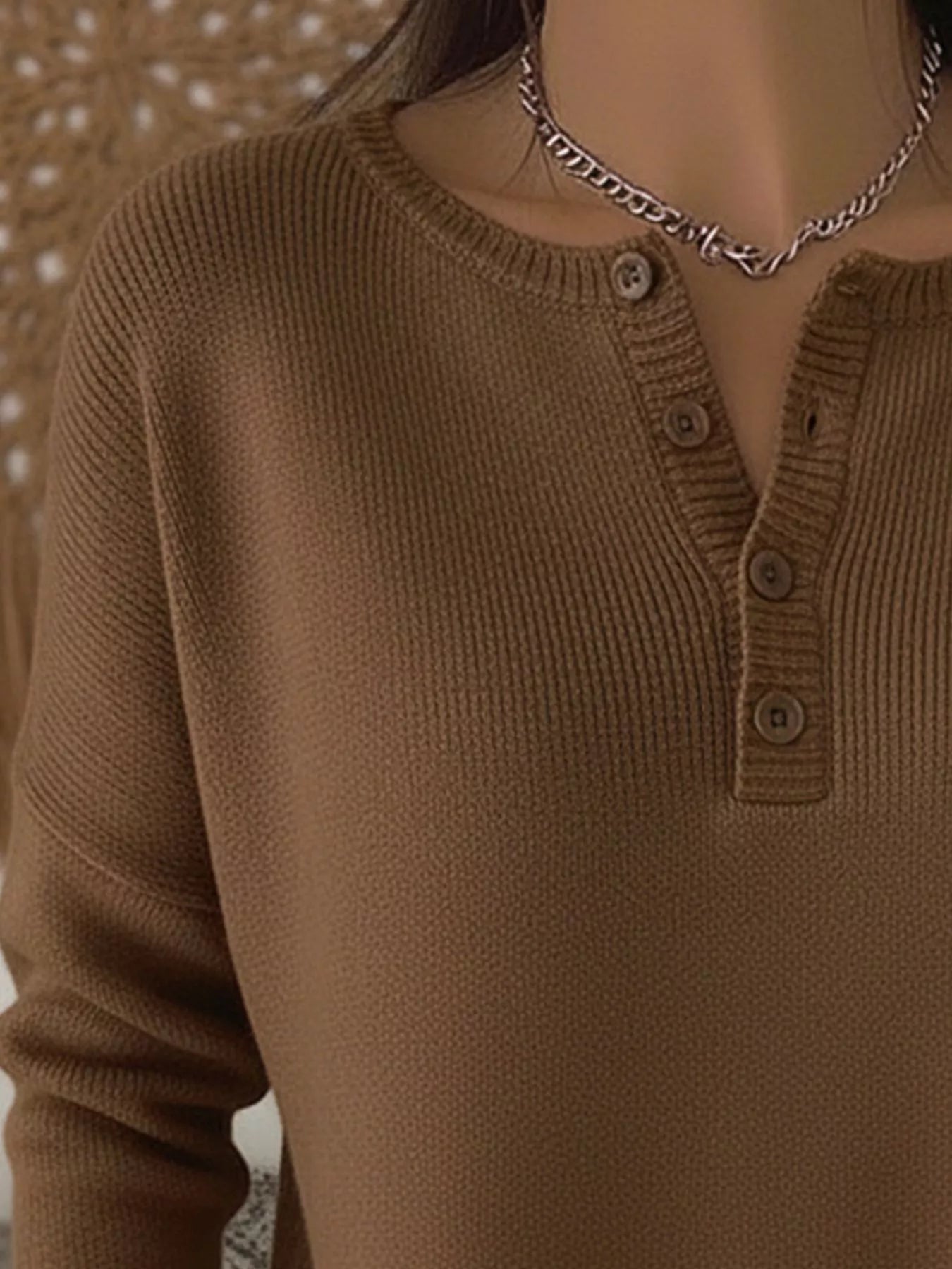 Brown buttoned long-sleeve knit top with a crew neckline and ribbed texture.