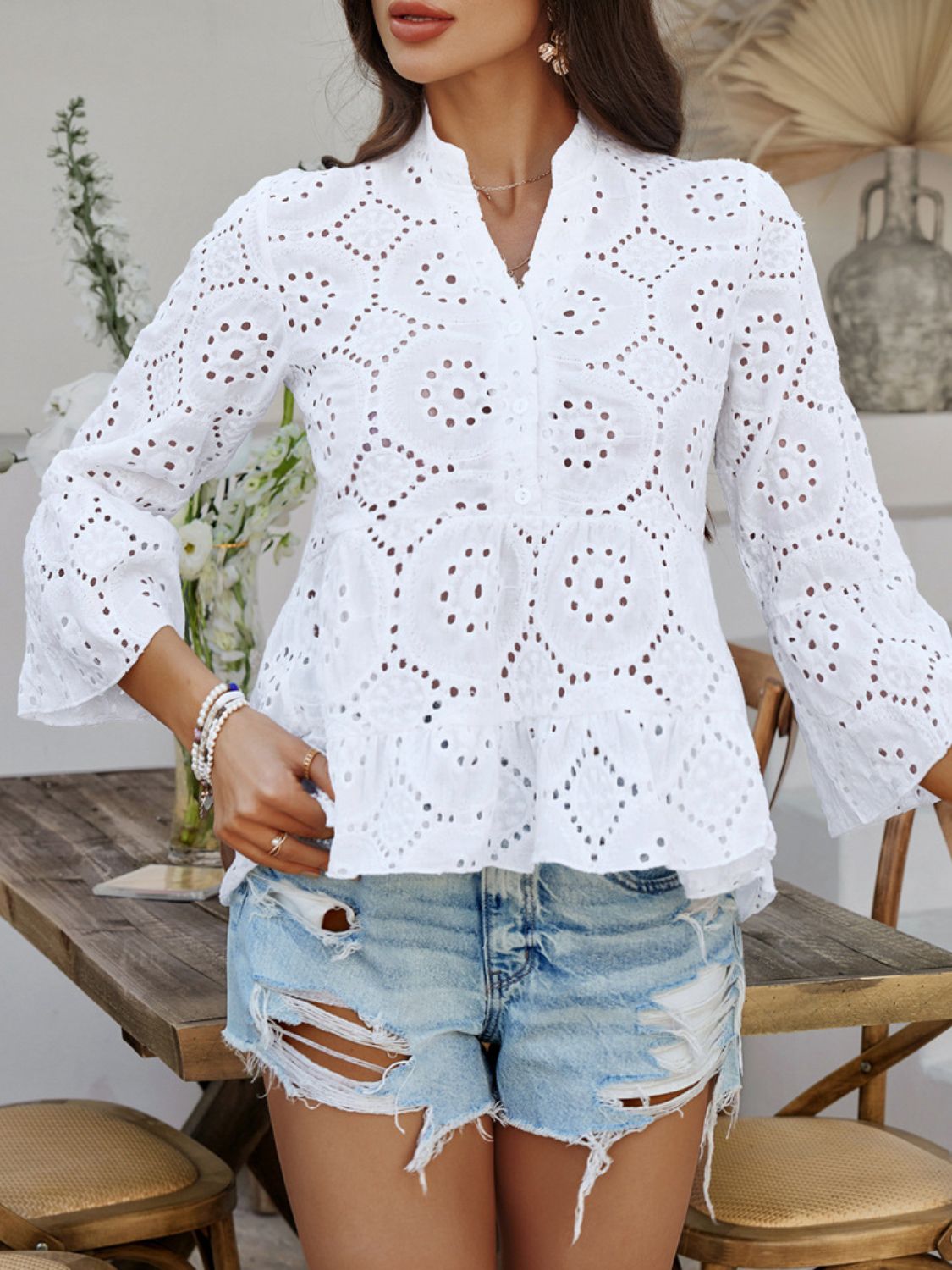 White eyelet embroidered peplum blouse with ruffles and bell sleeves.