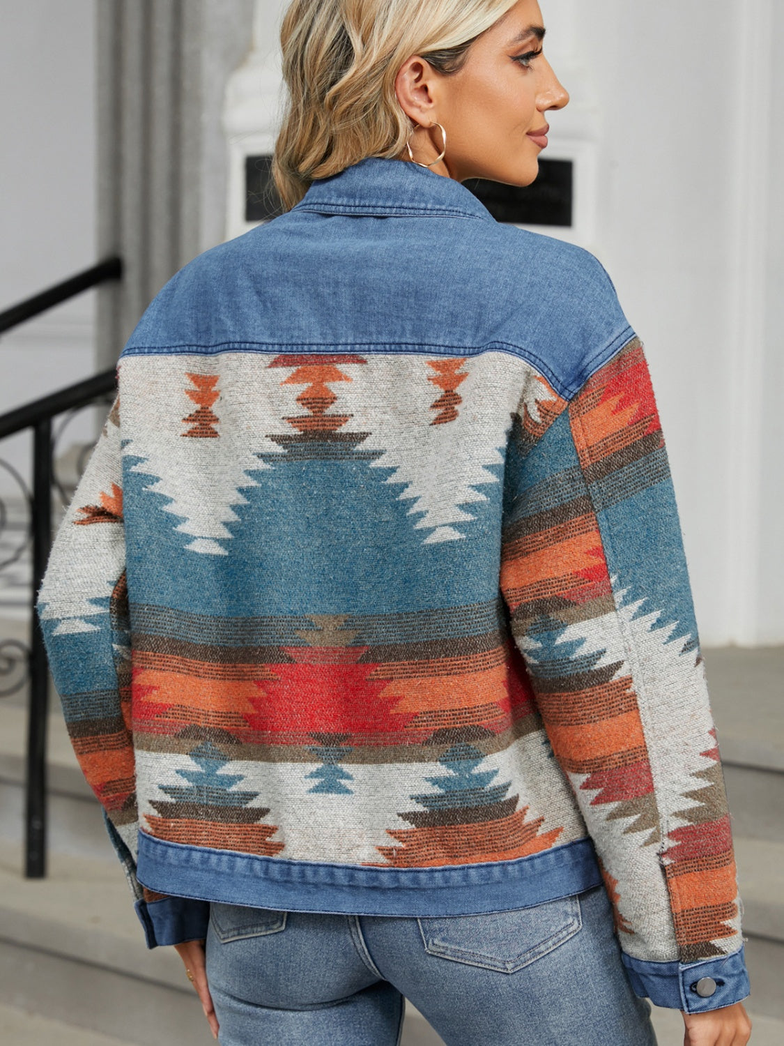Southwestern denim trucker jacket in dusty blue with a geometric pattern and button closure.