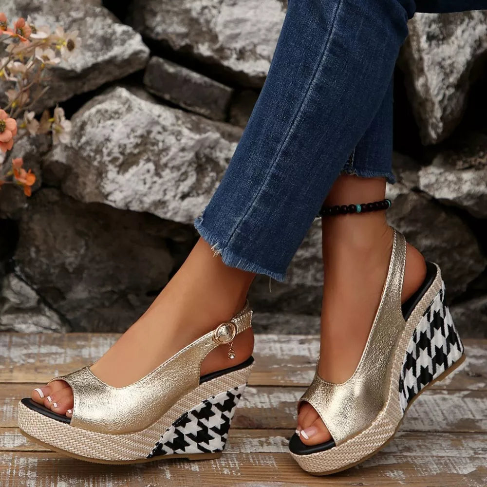 Gold open-toe wedge sandals with decorative buckle and houndstooth pattern wedge.
