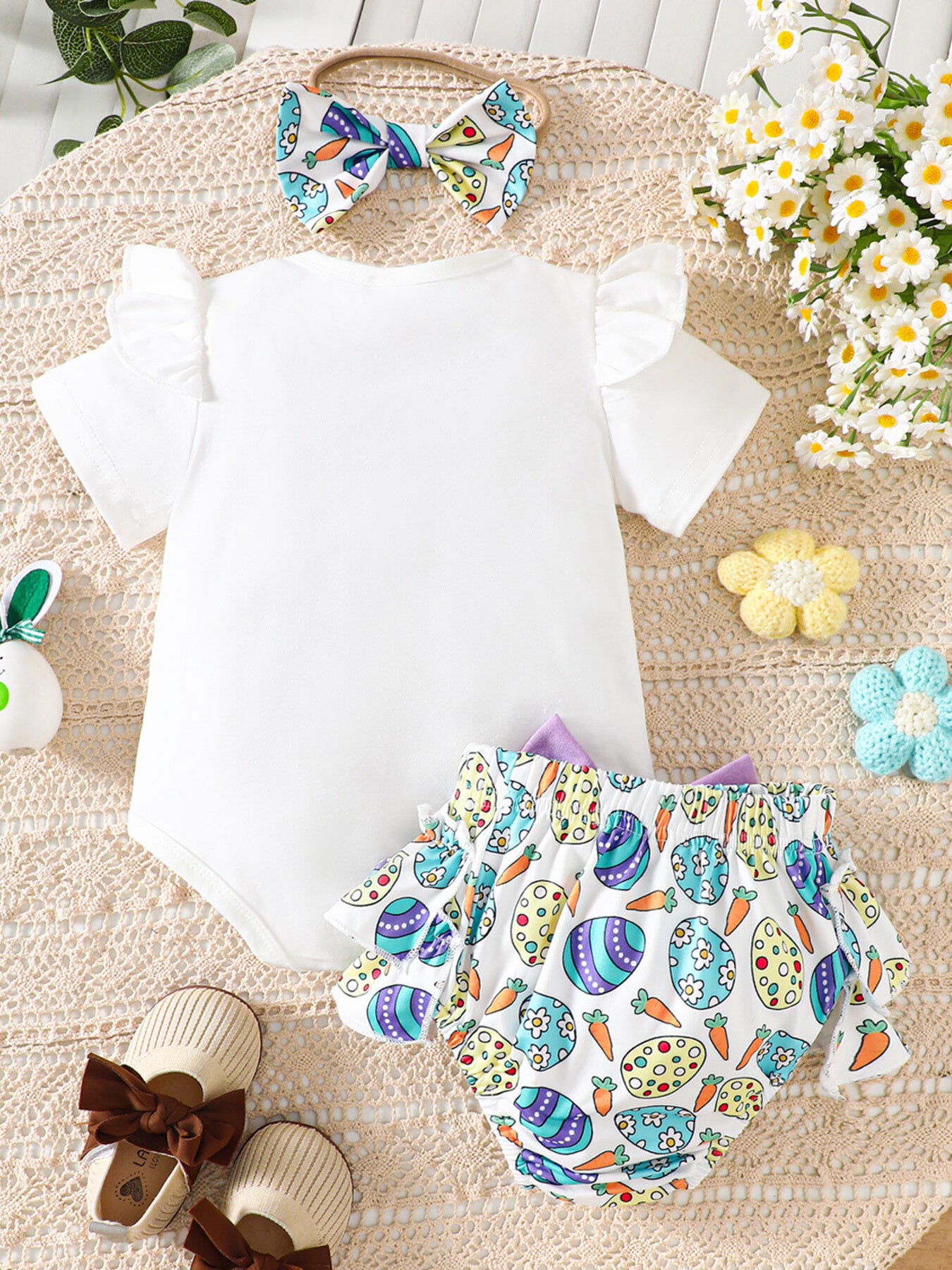 White baby bodysuit with ruffled sleeves and Easter egg print bloomers.