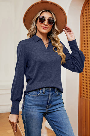 Dark blue collared blouse with buttoned lantern sleeves and a V-neck.