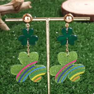 Gold clover dangle earrings with green glitter and colorful stripes