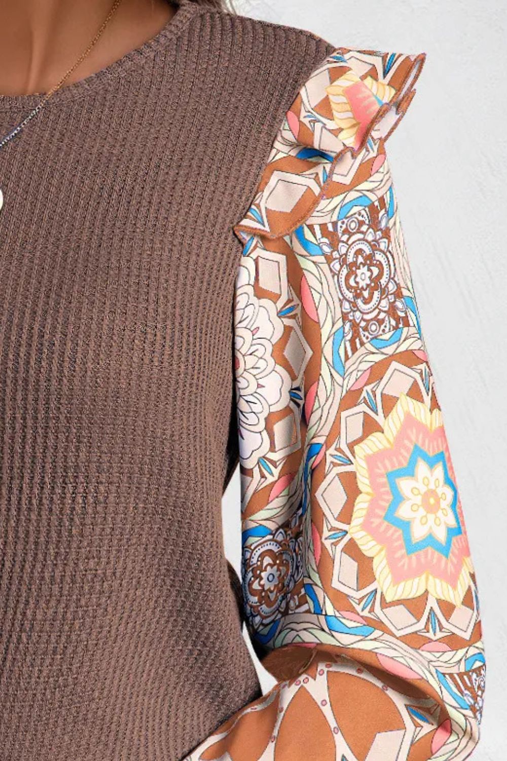 Brown knit top with ruffled printed sleeves and a crew neck.
