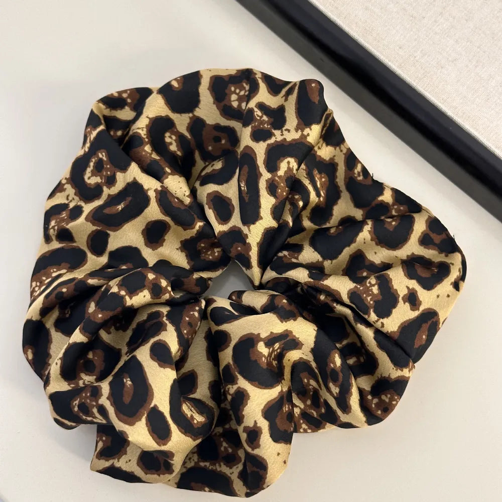 Leopard print silk scrunchie in tan with black spots.
