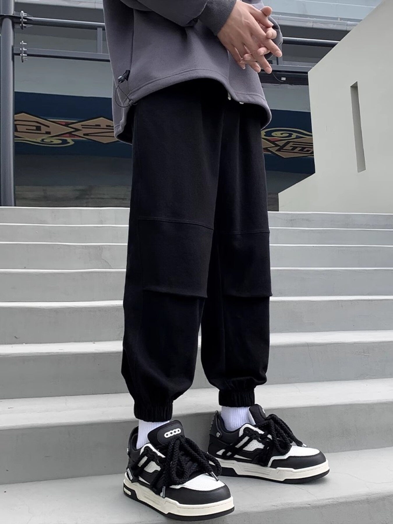 Black relaxed fit joggers with panel details and cuffed ankles.