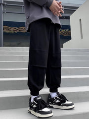 Black relaxed fit joggers with panel details and cuffed ankles.